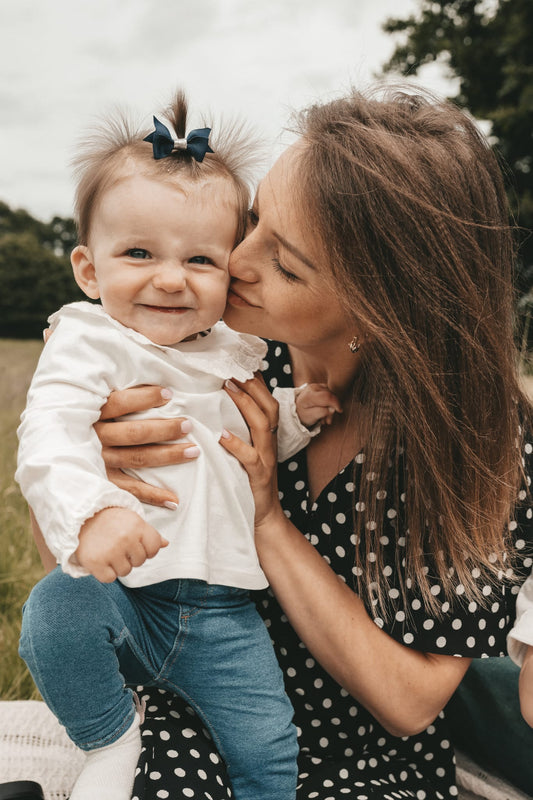 mother kissing happy daughter