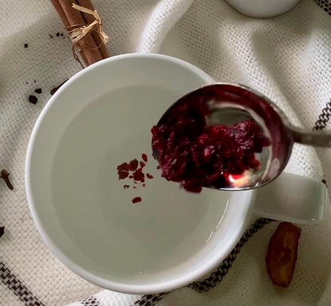 Whole cranberries and a cup of cranberry tisane — easy to brew cranberry tea